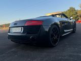 the rear end of a black audi sports car parked in a parking lot