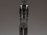 a bronze statue of a man standing on a black base