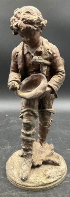 figurine en bronze représentant un garçon avec un chapeau et une canne