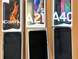 Quatre téléphones Samsung sont posés sur une table, dans une boîte