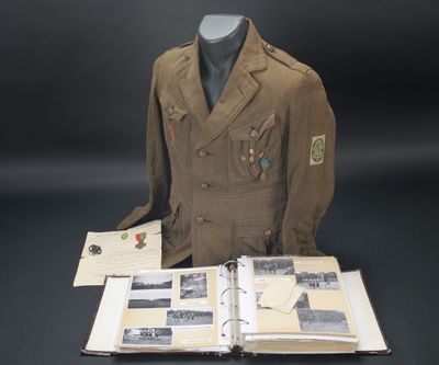 Une vieille veste militaire et un livre sont posés sur une table