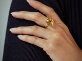 the woman is wearing a black shirt and a gold ring