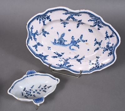 two blue and white dishes and a bowl on a stand