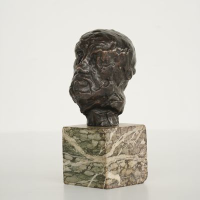 une sculpture représentant la tête d'un homme sur un bloc de marbre