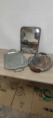une table en bois sur laquelle se trouvent un miroir, des casseroles et d'autres objets