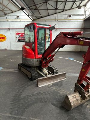 une pelleteuse rouge garée à l'intérieur d'un bâtiment