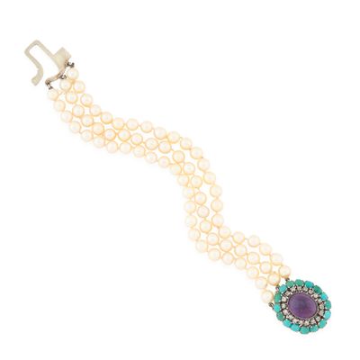 a close up of a bracelet with pearls and a purple stone