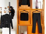 a coat rack with clothes and a purse on it