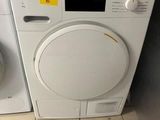 two washers and a dryer in a small room