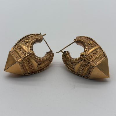 une paire de boucles d'oreilles dorées aux motifs raffinés
