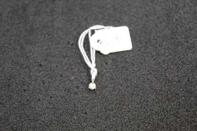 a white tag on a black surface with a white cord