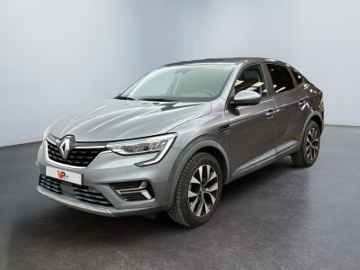 Une voiture grise est garée dans une pièce aux murs blancs.