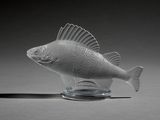 a glass fish figurine sitting on top of a table