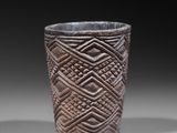 a close up of a cup on a table with a black background