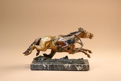 bronze statue of a horse and rider on a marble base