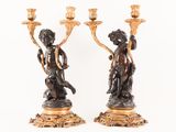 pair of antique bronze figurines of a boy and a girl holding candles