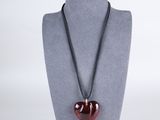 necklace with a red heart on a black cord on a mannequin