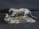 statue of a tiger on a rock on a black background
