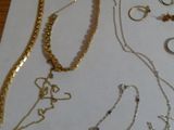 beaucoup de bijoux en or posés sur une table à côté d'un sac à main