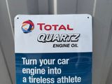 a sign that says total quartz engine oil turn your car engine into a tireless athlete