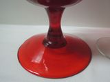 a red wine glass sitting on a table next to a glass of wine
