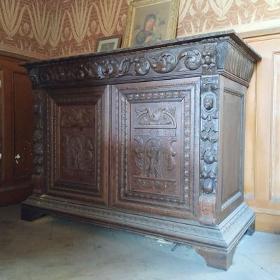 un grand coffre en bois orné de sculptures, dans une pièce