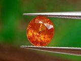 un gros plan d'un diamant jaune tenu par une pince