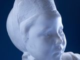 a white statue of a woman with a hat on her head