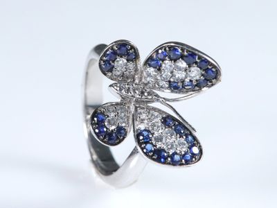 un gros plan d'une bague sertie de diamants bleus et blancs