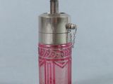 une petite bouteille en verre rose à laquelle est attachée une chaîne