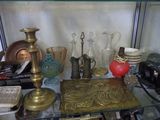a glass shelf with a lot of antique items on it