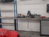 a red car parked in a garage next to a work bench