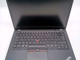 a black laptop with a red button on the keyboard