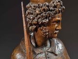 an old wooden statue of a man with a crown on his head