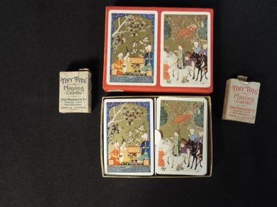 three small tins with pictures of people riding horses and a box of cigarettes