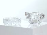 un bol en verre et un bougeoir en verre posés sur une table blanche