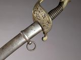 an old sword with a metal handle on a gray background