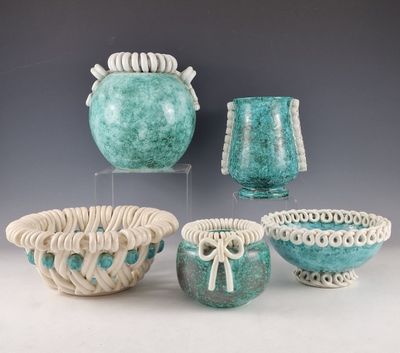 three vases and a bowl are sitting on a table