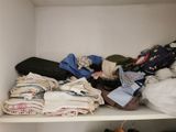 a white shelf with a lot of clothes on it