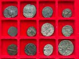 an assortment of ancient roman coins in a red display case
