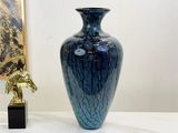 a blue vase sitting on a table next to a gold horse statue