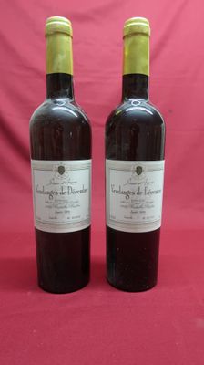 two bottles of wine sitting on top of a red table