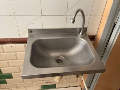 un évier en acier inoxydable dans le coin d'une salle de bains