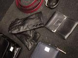 leather gloves, wallets, and other items are laid out on the floor