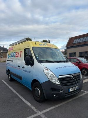 une camionnette bleue et jaune garée sur un parking