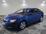 a blue chevrolet cruz parked in a garage with a checkered floor