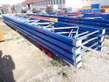 a large pile of steel beams sitting on top of a dirt field