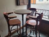 une petite table et deux chaises devant une fenêtre