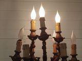 a chandelier that has five lit candles on it