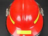 a red fireman ' s helmet on a black background